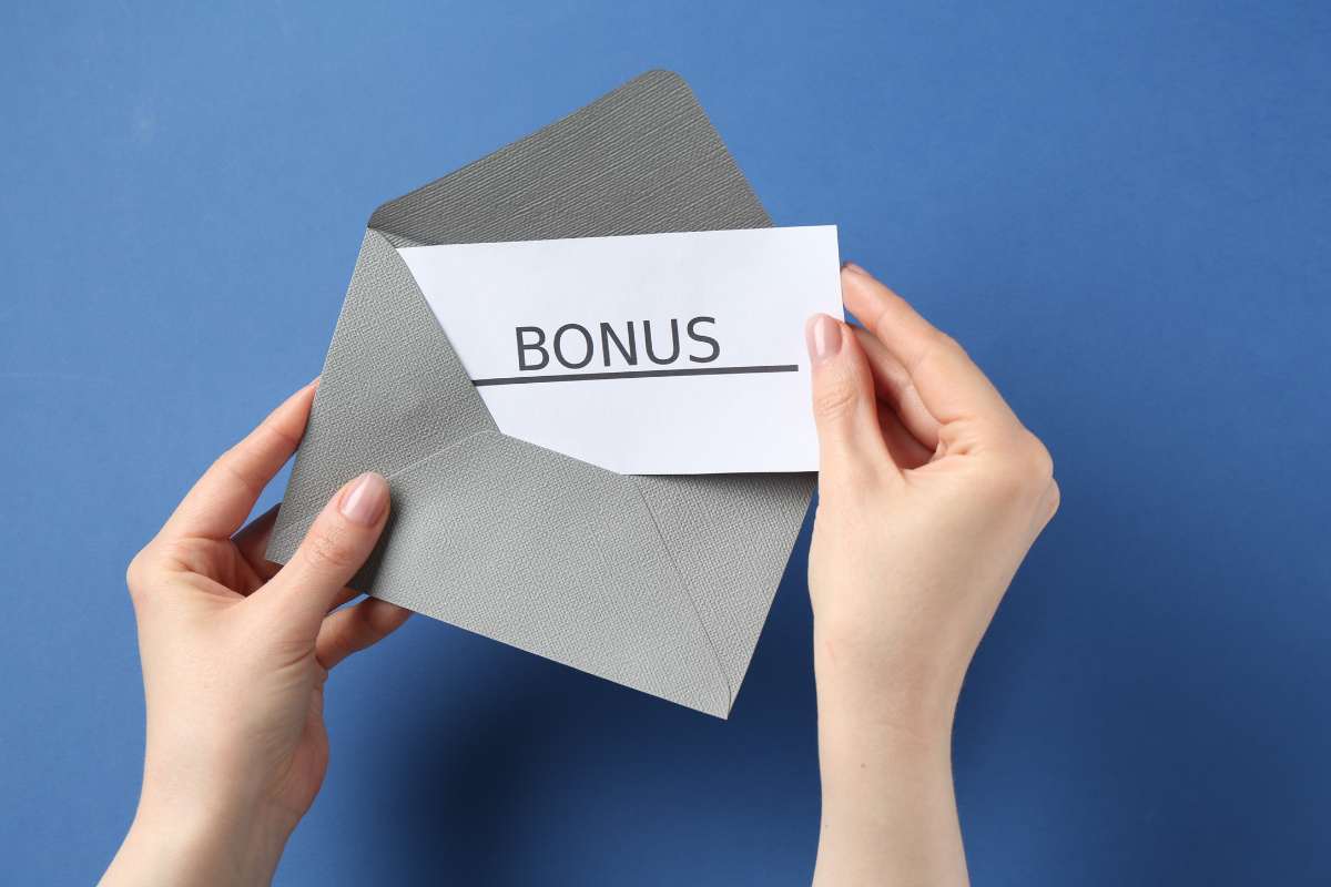 persona apre busta con dentro un biglietto con scritto bonus
